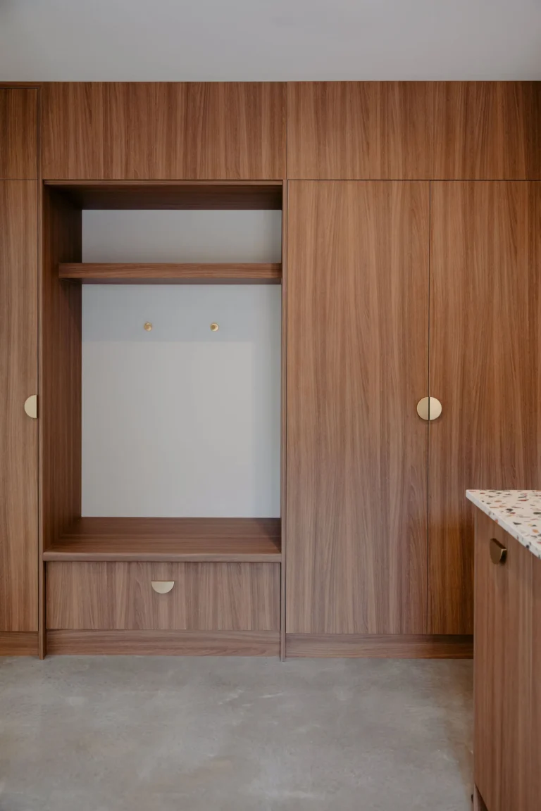 Built-in timber mudroom storage with a bench seat, open hanging nook and brass hardware