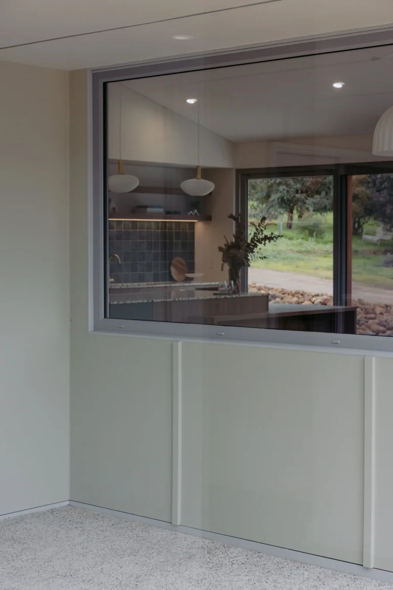 Internal servery window looking through to the kitchen and bushland garden beyond