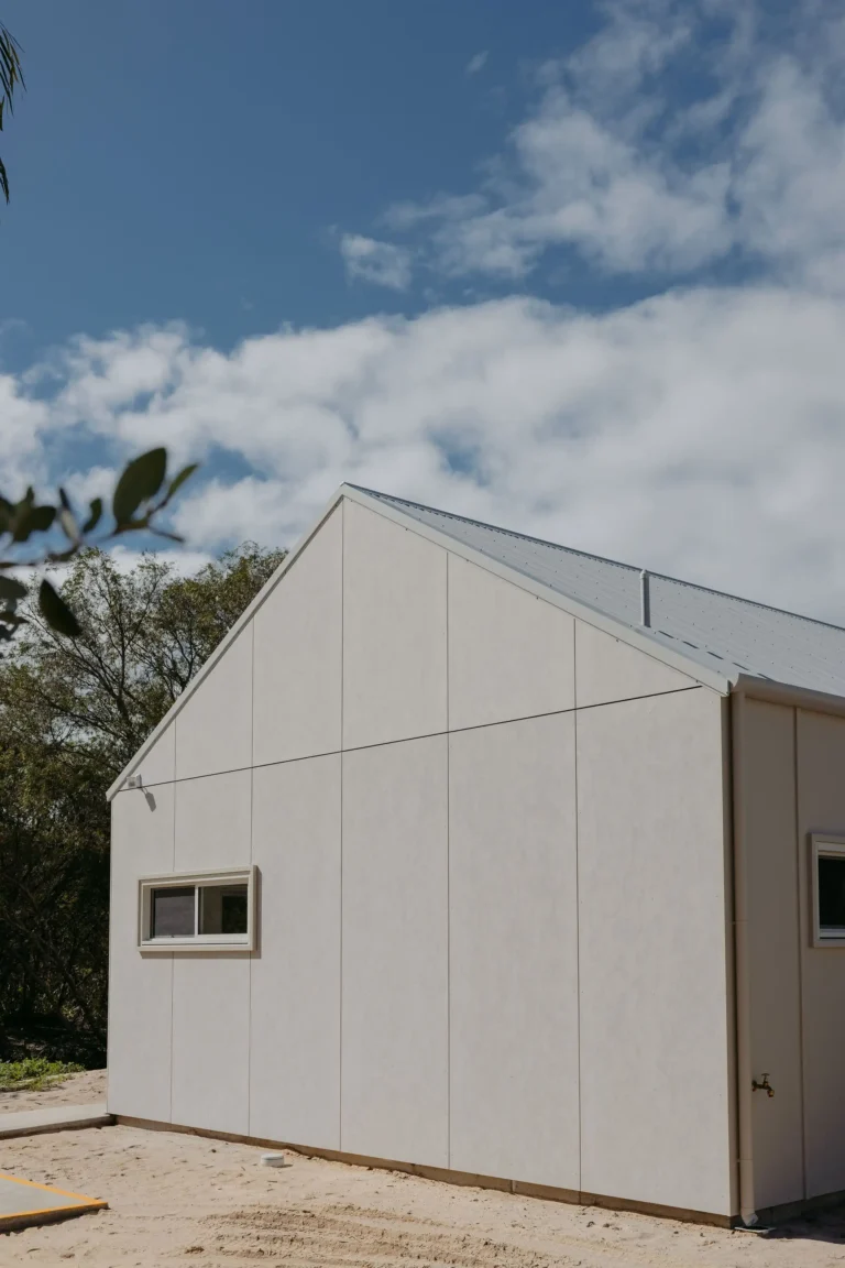 Barn-style gable in pale panelled cladding under a blue sky