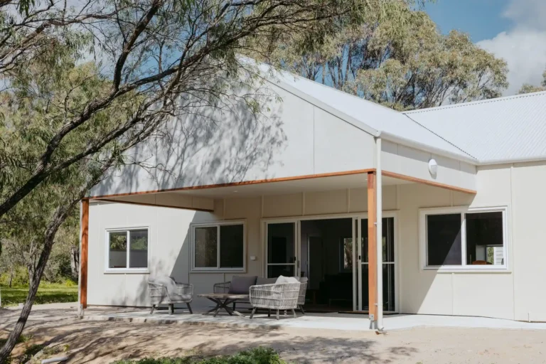 Kyle Andrews Foundation Cabin exterior with covered alfresco, outdoor lounge setting and sliding doors under gum trees