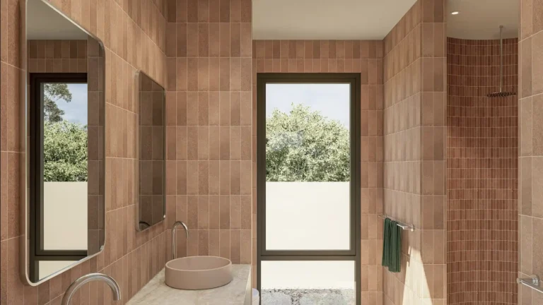 Ensuite bathroom in Project Harwood featuring terracotta subway tiles, dual round vessel basins on a marble benchtop, freestanding bath, and floor-to-ceiling window overlooking lush garden in Dunsborough WA